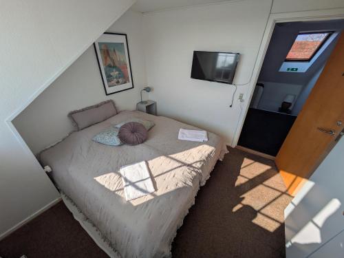 a small bedroom with a bed and a television at Restaurant Backhaus in Ribe