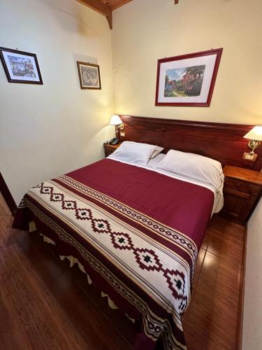 a bedroom with a large bed with a wooden headboard at Hosteria Sirenuse in Mar del Plata