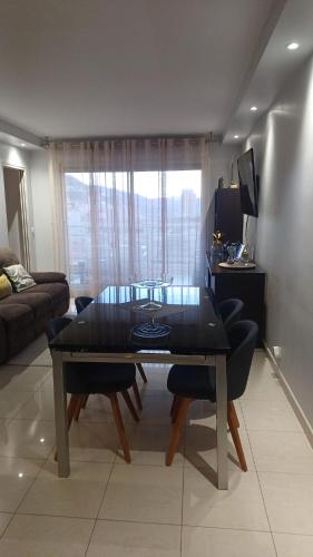 un salon avec une table, des chaises et un canapé dans l'établissement Beau appartement avec garage fermé, à Beausoleil