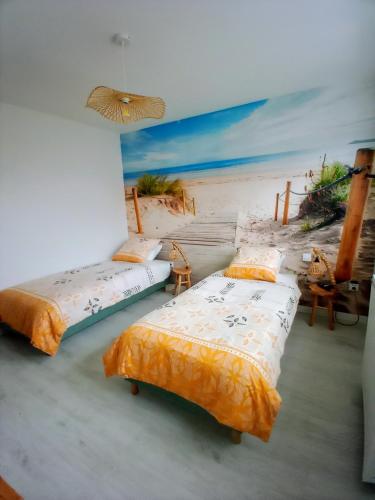- une chambre avec 2 lits et une peinture sur la plage dans l'établissement Villa Ptit Rene, à Dunkerque