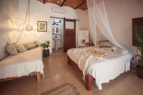 a bedroom with two beds and a sink at Casa Botanica in Lo de Marcos