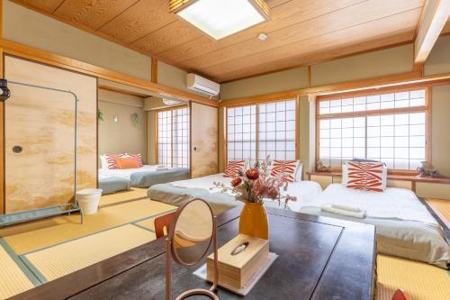 a large room with two beds and a table at 天満橋 Guest House#有电梯 #步行大阪城 #赏樱花必打卡点 #直达梅田 京都 #免费wifi in Osaka