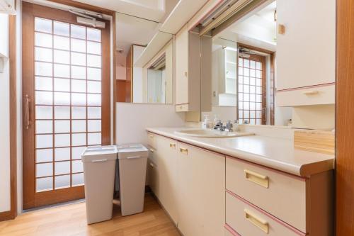 un baño con lavabo y espejo en 天満橋 Guest House#有电梯 #步行大阪城 #赏樱花必打卡点 #直达梅田 京都 #免费wifi, en Osaka