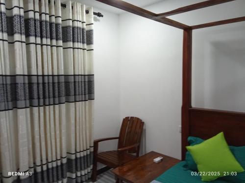 a room with a table and a chair and a curtain at Solaces transit residence in Liyanagemulla