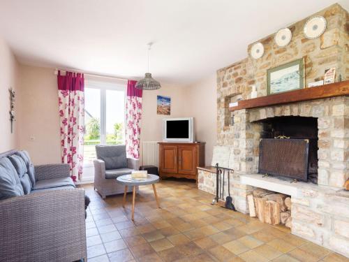 - un salon avec une cheminée en pierre et une télévision dans l'établissement Holiday Home Le Pré Salé by Interhome, à Portbail