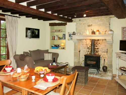 un salon avec une table et une cheminée dans l'établissement Holiday Home Héroult by Interhome, à Canchy