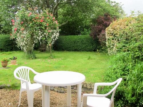 - une table blanche et deux chaises dans le jardin dans l'établissement Holiday Home Héroult by Interhome, à Canchy