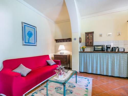 a living room with a red couch and a table at Apartment L'Uccelliera-2 by Interhome in Canneto