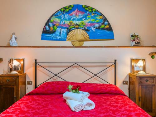 a bedroom with a red bed with a stained glass window at Apartment L'Uccelliera-2 by Interhome in Canneto