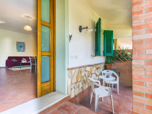 a patio with a table and chairs and a brick wall at Apartment L'Uccelliera-2 by Interhome in Canneto