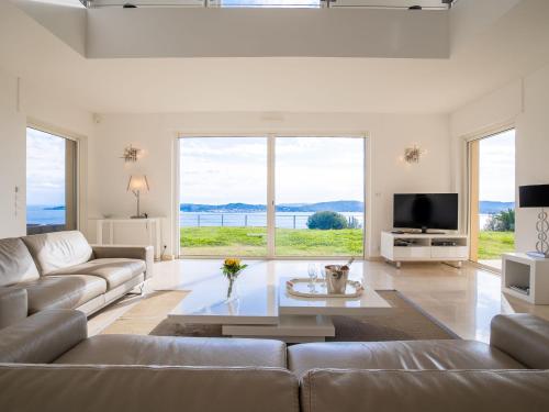 un salon avec un canapé et une grande fenêtre dans l'établissement Villa Lei Suve by Interhome, à Grimaud