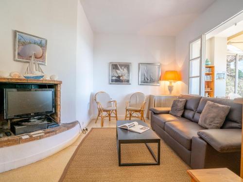 un salon avec un canapé et une télévision dans l'établissement Holiday Home Pigeon Vole by Interhome, aux Issambres