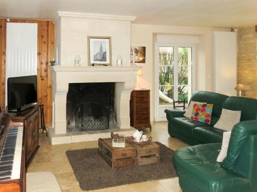 - un salon avec un canapé vert et une cheminée dans l'établissement Holiday Home Gîte de l'Epine by Interhome, à Cambes-en-Plaine