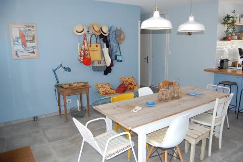 une salle à manger avec une table et des chaises en bois dans l'établissement La Maison d'ETE, à Noirmoutier-en-l'lle