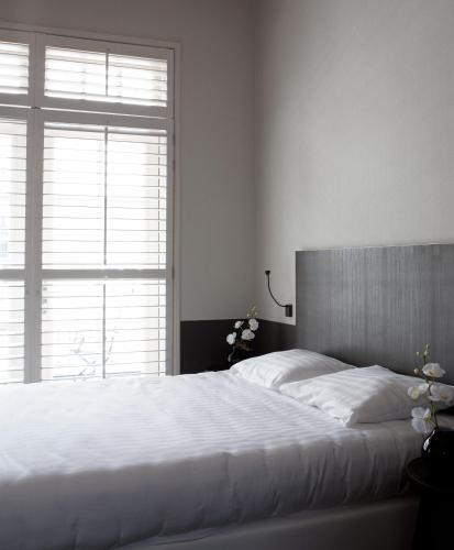 a bedroom with a white bed with a large window at Fletcher Hotel - Restaurant Nautisch Kwartier in Huizen