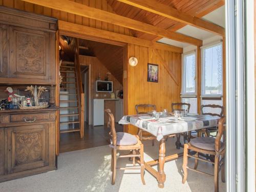 une cuisine et une salle à manger avec une table et des chaises dans l'établissement Chalet Petit Chalet à la Plage by Interhome, à Cléder