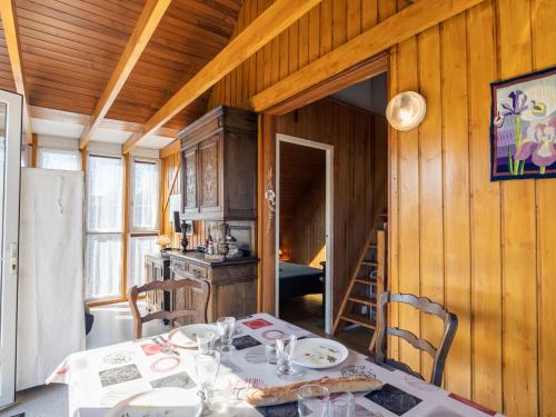 une salle à manger avec une table et une cuisine dans l'établissement Chalet Petit Chalet à la Plage by Interhome, à Cléder