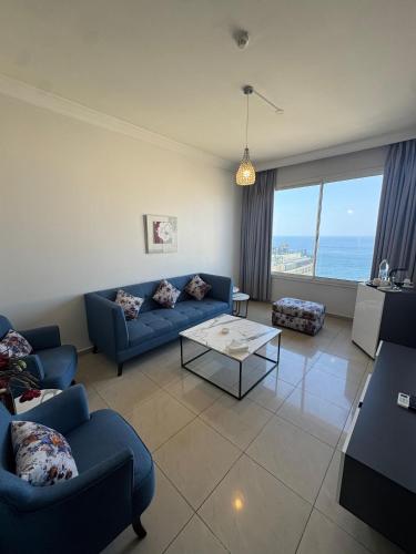a living room with blue couches and a view of the ocean at Ny Suites in Beirut