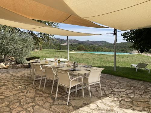 - une table avec des chaises blanches et un parasol dans l'établissement Holiday Home La Princesse by Interhome, à Saint-Maime