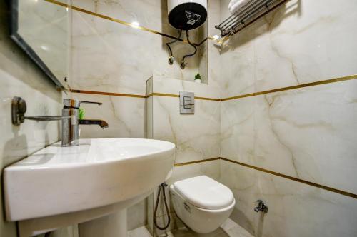 a bathroom with a white sink and a toilet at Hotel Kuber International - New Delhi Train Station in New Delhi