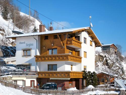 a large building with wooden balconies in the snow at Apartment Garni Regina-2 by Interhome in Kappl