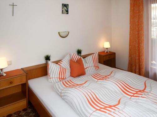 a bedroom with a bed with orange and white pillows at Apartment Garni Regina-2 by Interhome in Kappl