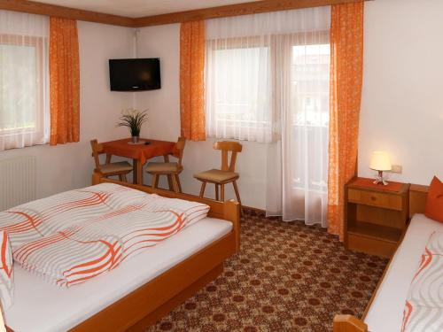 a hotel room with a bed and a table and chairs at Apartment Garni Regina-2 by Interhome in Kappl