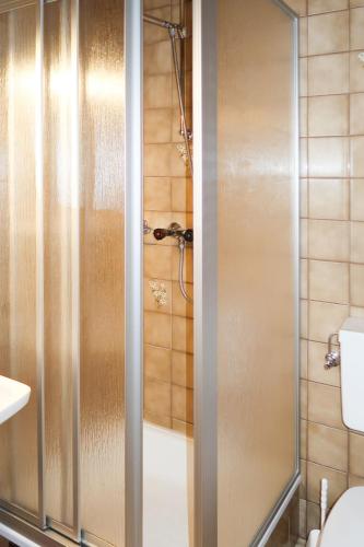 a shower with a glass door in a bathroom at Apartment Garni Regina-2 by Interhome in Kappl