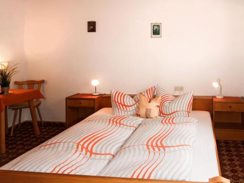a bedroom with a bed with striped sheets and two tables at Apartment Garni Regina-2 by Interhome in Kappl