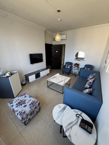 a living room with a blue couch and a tv at Ny Suites in Beirut