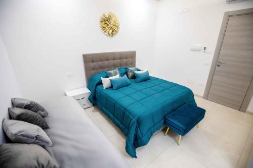 a bedroom with a blue bed in a white room at Relais San Giorgio in Pignataro Maggiore