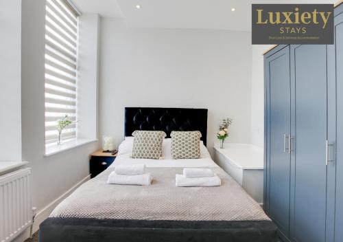 a white bedroom with a large bed with two pillows at Gorgeous 1BR Apt - City Centre By Luxiety Stays in Southend-on-Sea
