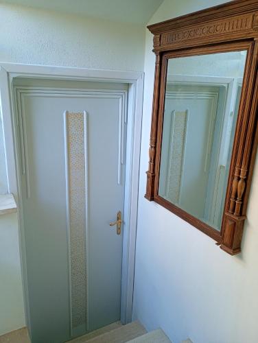 a bathroom with a door and a mirror at Holiday Home Carina in Dolceacqua