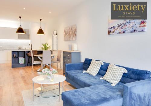 a living room with a blue couch and a table at Gorgeous 1BR Apt - City Centre By Luxiety Stays in Southend-on-Sea