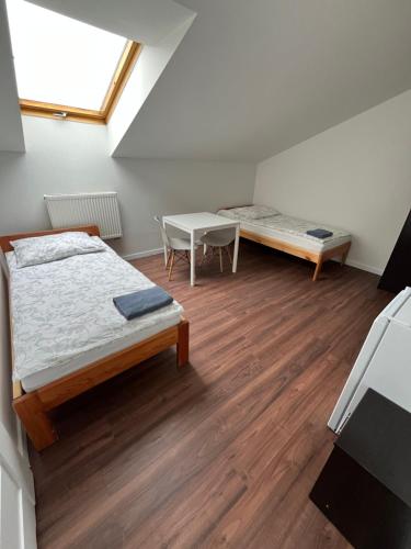 a bedroom with a bed and a table and a bench at Pokoje Gościnne w WSE in Białystok