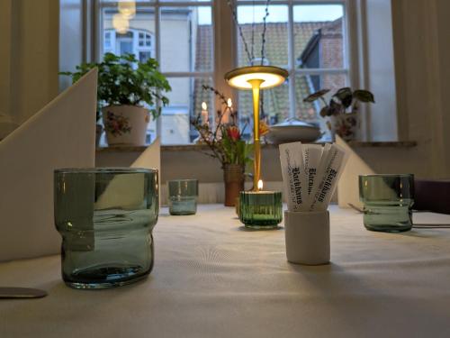a table with glass vases and candles on it at Restaurant Backhaus in Ribe