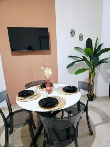 a dining room table with two chairs and a tv at Kasa in Centro INTERO APPARTAMENTO in Reggio Calabria