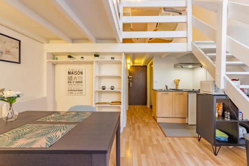 Il comprend une cuisine et un salon avec une mezzanine. dans l'établissement L'alcôve Grand studio, proche Place Nationale, à Montauban