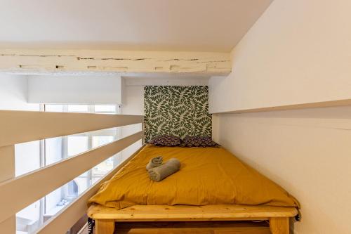 - un petit lit dans l'angle de la chambre dans l'établissement L'alcôve Grand studio, proche Place Nationale, à Montauban