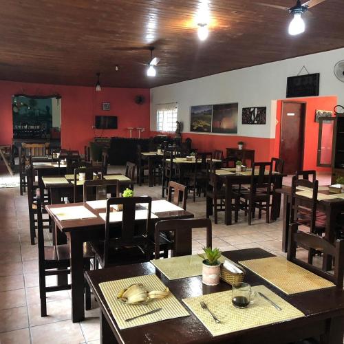 an empty restaurant with wooden tables and chairs at Pousada & Camping Santa Clara in Santa Helena