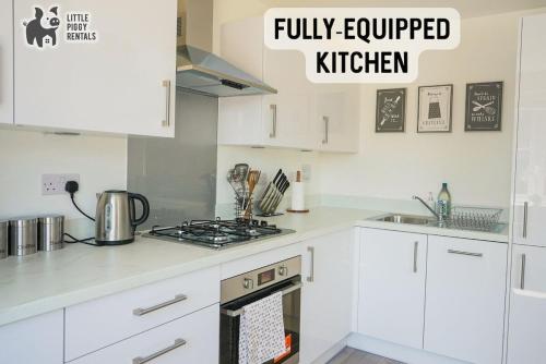 a kitchen with white cabinets and a stove top oven at Central 2 Bedroom Flat with 2 Parking Spaces, Quiet and Modern Stay in Peterborough