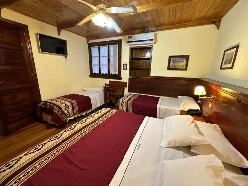 a hotel room with two beds and a tv at Hosteria Sirenuse in Mar del Plata