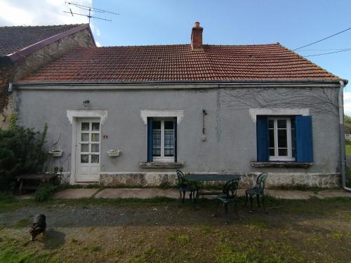 une maison avec une table et des chaises devant dans l'établissement En pleine campagne berrichonne, à Pérassay