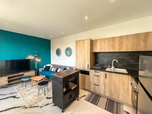 une cuisine avec un évier et un salon dans l'établissement L'Escale Cancalaise maison 6 personnes, à Cancale