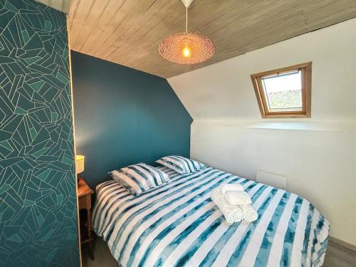 - une chambre avec un lit bleu et blanc et une fenêtre dans l'établissement L'Escale Cancalaise maison 6 personnes, à Cancale