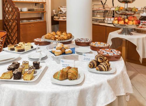 a table filled with different types of pastries and desserts at Welcome Hotel in Legnano