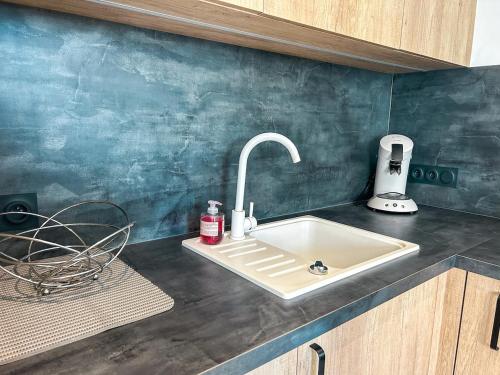 - un évier de cuisine avec un robinet sur un comptoir dans l'établissement L'Escale Cancalaise maison 6 personnes, à Cancale