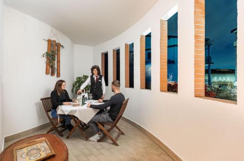 a group of people sitting around a table in a room at Welcome Hotel in Legnano