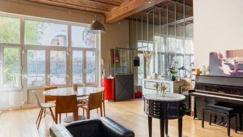 un salon avec une table et un piano dans l'établissement Le Jardin de Charenton à Paris, à Paris