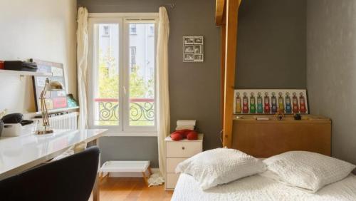 une chambre avec un lit, un bureau et une fenêtre dans l'établissement Le Jardin de Charenton à Paris, à Paris